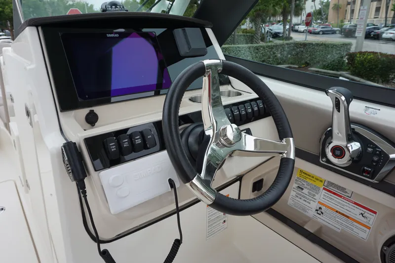 Slide: The Image of 2026 Boston Whaler 240 Vantage helm with steering wheel and control panel. - 22