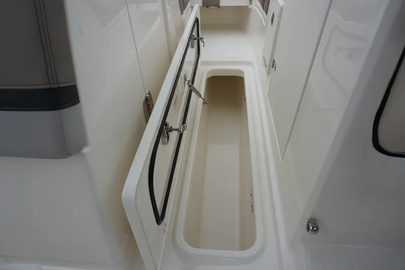 Slide: The Image of 2026 Boston Whaler 240 Vantage storage compartment with open hatch, showcasing interior space. - 27