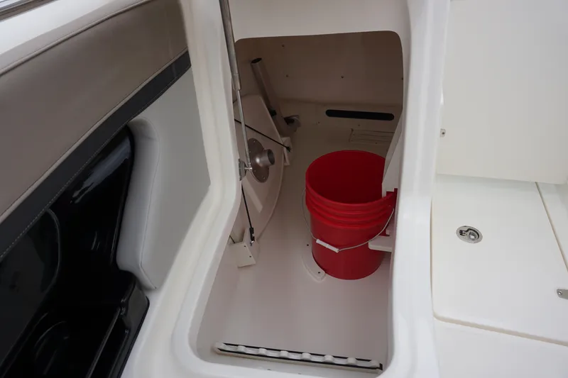Slide: The Image of Storage compartment in 2026 Boston Whaler 240 Vantage boat with red bucket inside. - 34