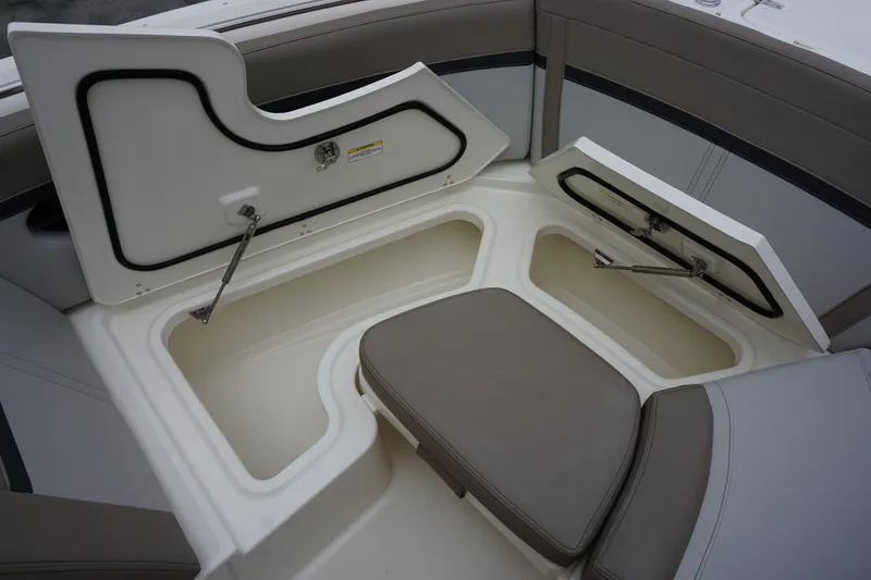Slide: The Image of 2026 Boston Whaler 240 Vantage boat storage compartments with open hatches and cushioned seating. - 35