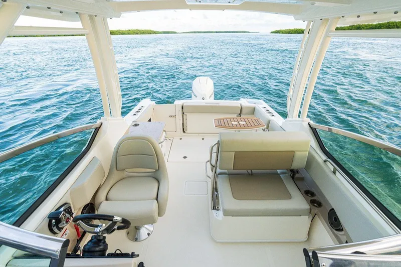 Slide: The Image of Manufacturer Provided Image: 2026 Boston Whaler 240 Vantage boat interior with seating, steering wheel, and ocean view. - 6