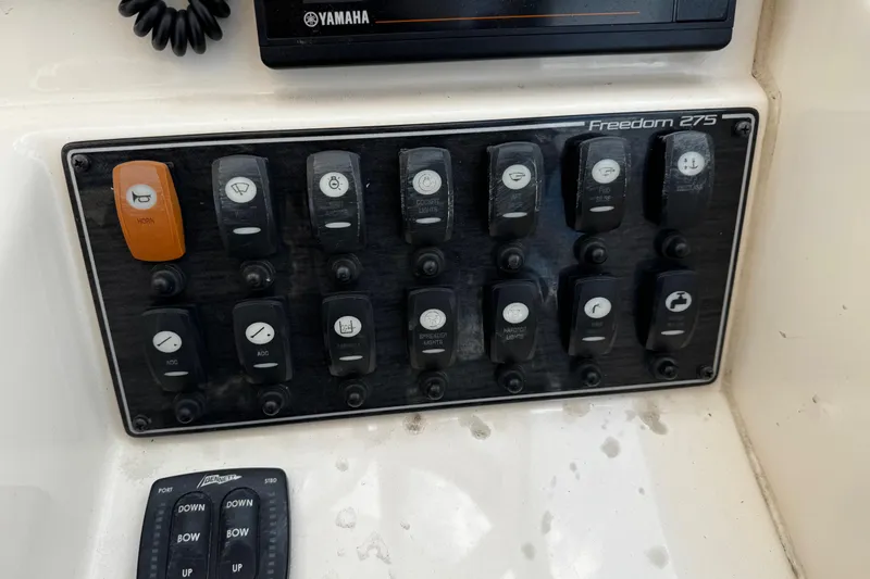 Slide: The Image of Control panel of 2019 Grady-White Freedom 275 boat with labeled switches and buttons. - 16