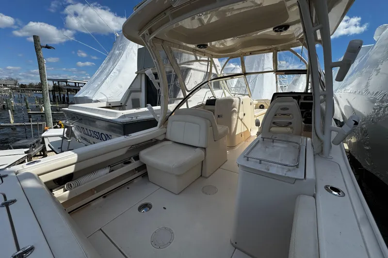 Slide: The Image of 2019 Grady-White Freedom 275 boat interior with seating and helm, docked at marina. - 20