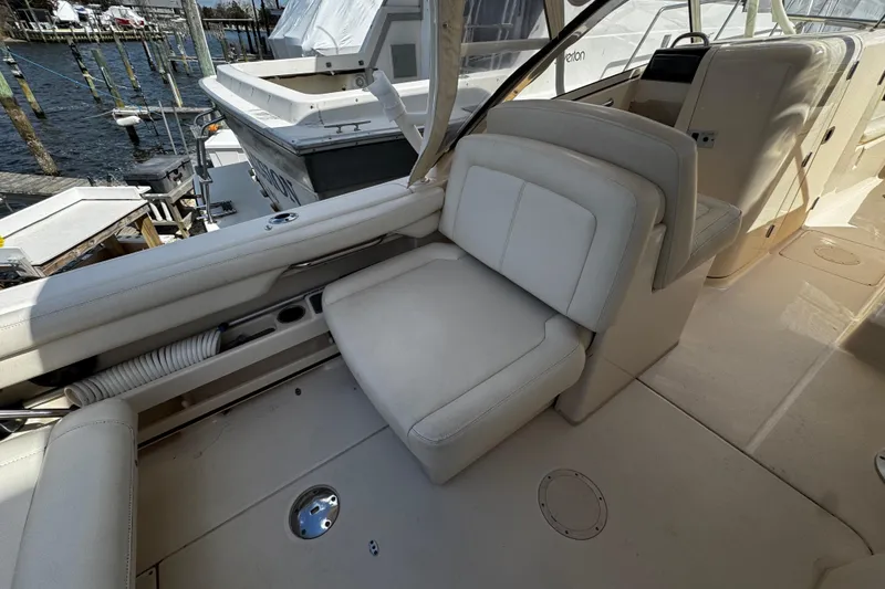 Slide: The Image of 2019 Grady-White Freedom 275 boat interior with white seating and dock view. - 34