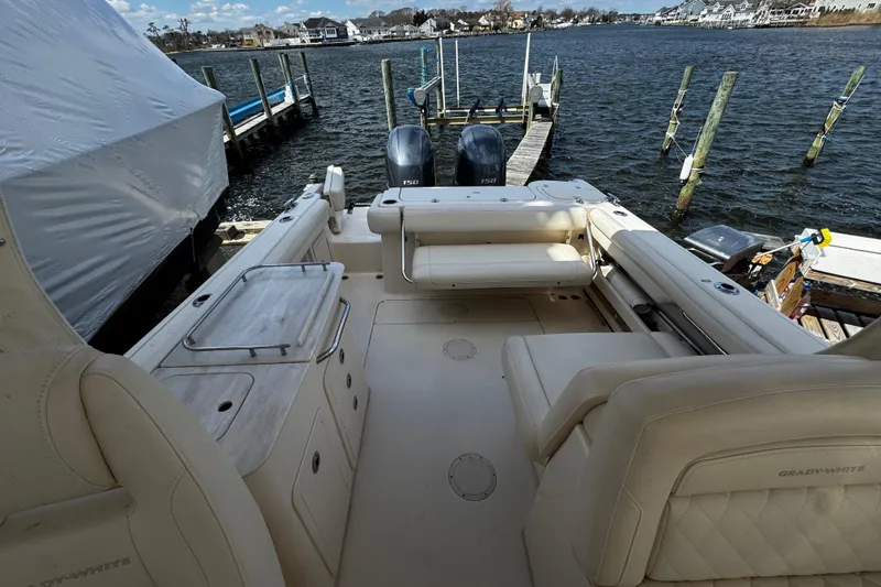 Slide: The Image of 2019 Grady-White Freedom 275 boat interior with seating, docked by the water. - 36