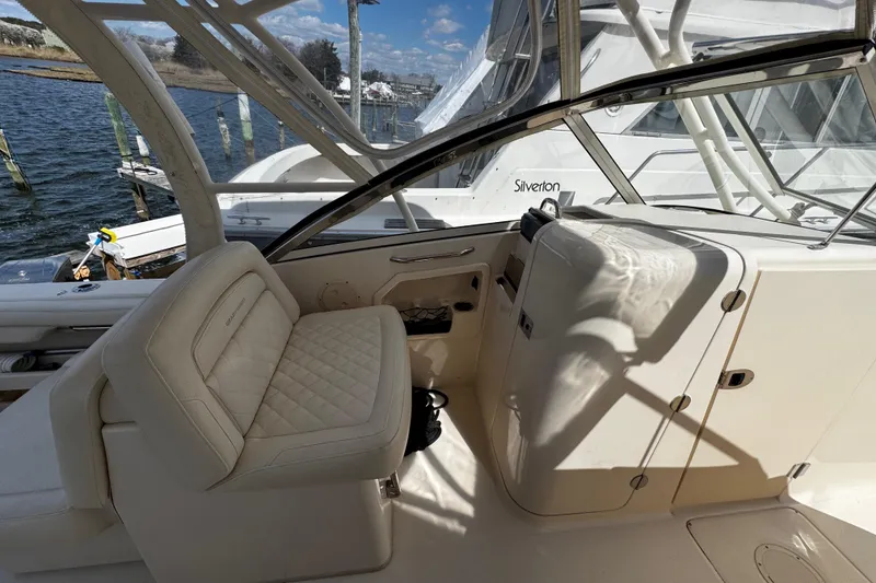 Slide: The Image of 2019 Grady-White Freedom 275 boat interior with cushioned seating and helm. - 40