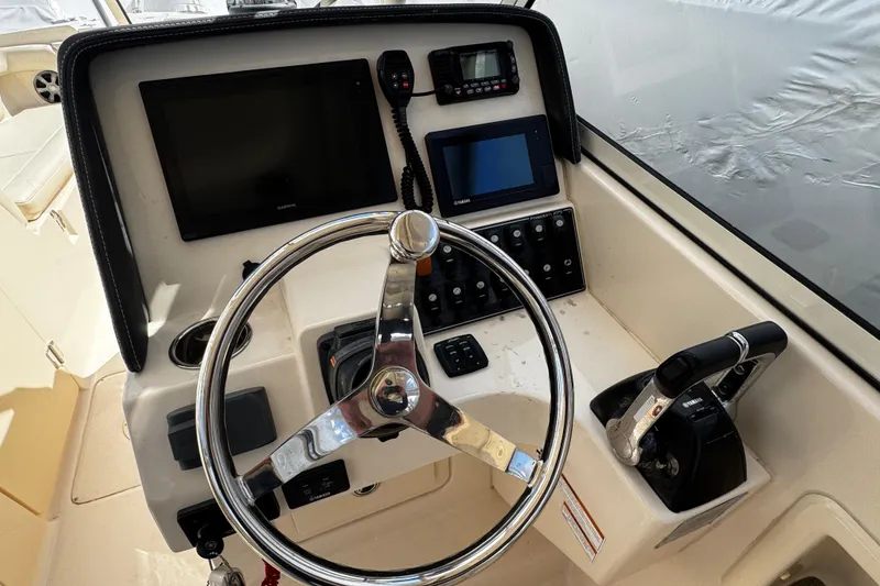 Slide: The Image of 2019 Grady-White Freedom 275 boat dashboard with steering wheel and control panel. - 41