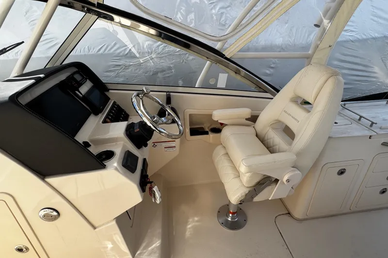 Slide: The Image of 2019 Grady-White Freedom 275 boat cockpit with steering wheel and captain's chair. - 42