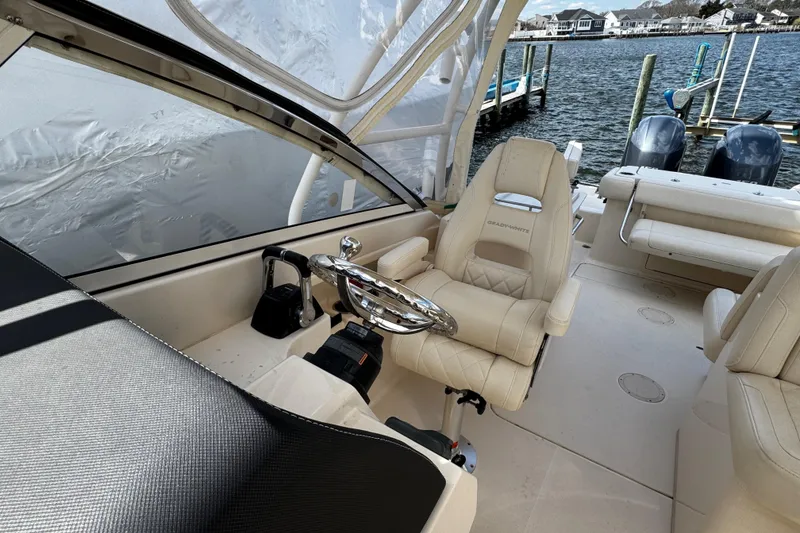 Slide: The Image of Interior of a 2019 Grady-White Freedom 275 boat with luxurious seating and steering wheel. - 44