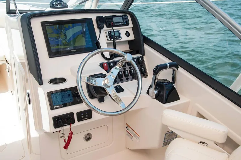 Slide: The Image of Manufacturer Provided Image: 2019 Grady-White Freedom 275 boat helm with steering wheel, controls, and navigation screens. - 8
