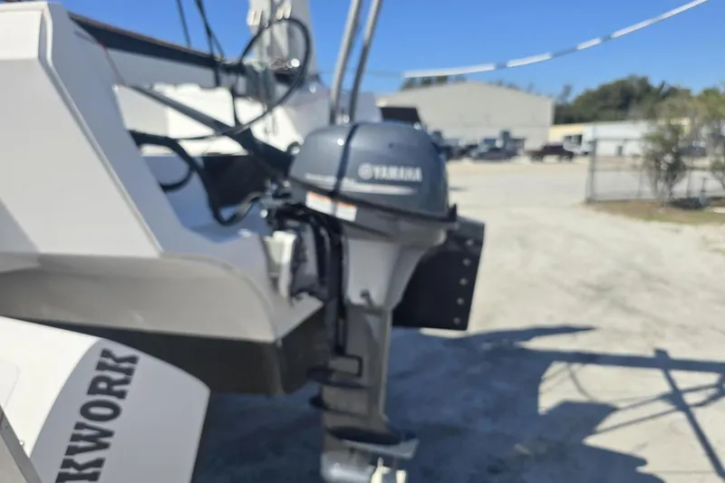 Slide: The Image of Outboard motor on a 2021 Corsair 880 Sport boat in a sunny outdoor setting. - 9