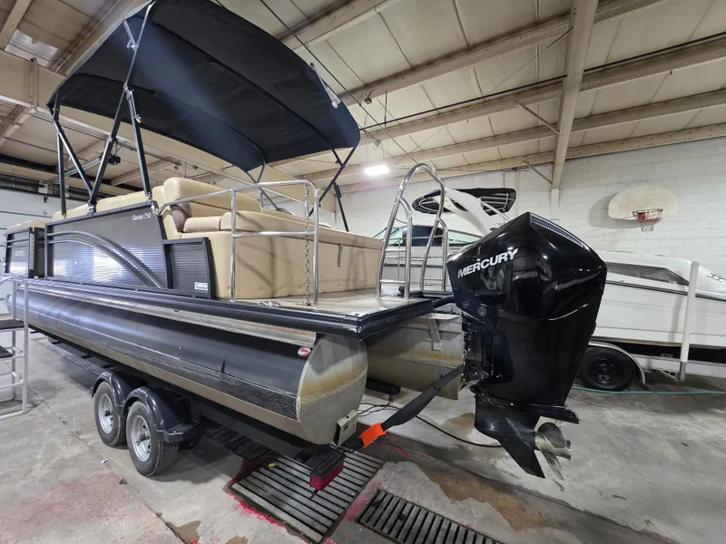 Slide: The Image of 2019 Harris 250 CR pontoon boat with Mercury engine in warehouse. - 2