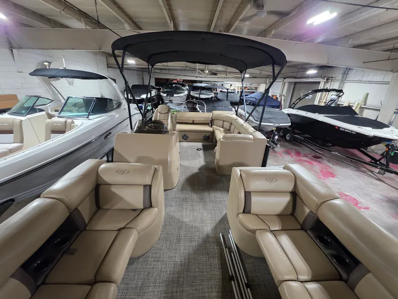 Slide: The Image of Interior view of a 2019 Harris 250 CR pontoon boat in a storage facility. - 5