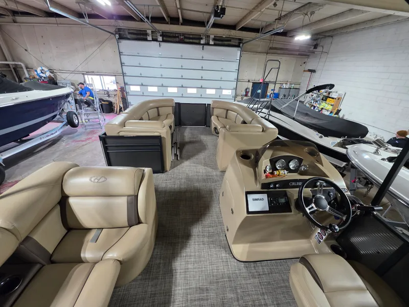 Slide: The Image of Interior view of a 2019 Harris 250 CR pontoon boat in a workshop. - 6