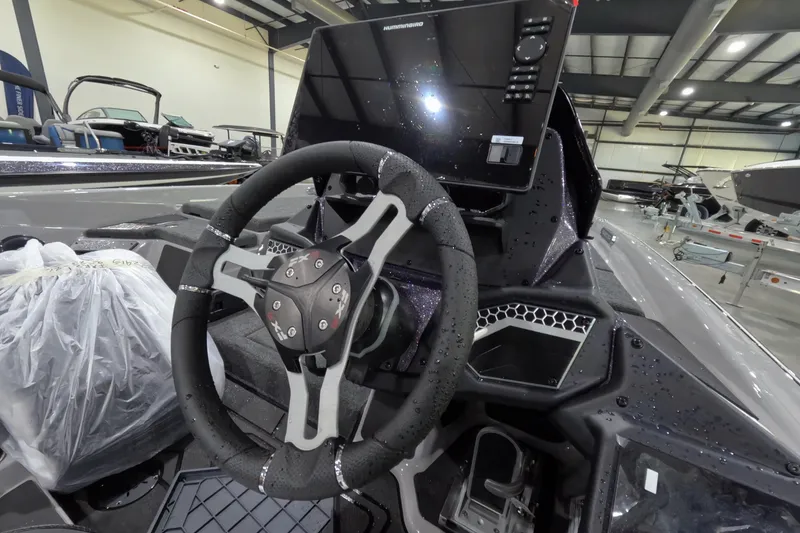 Slide: The Image of Interior of a 2026 Skeeter boat featuring a modern steering wheel and dashboard controls. - 12