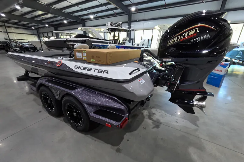 Slide: The Image of 2026 Skeeter boat with Yamaha engine in a showroom, featuring sleek design and dual-axle trailer. - 3