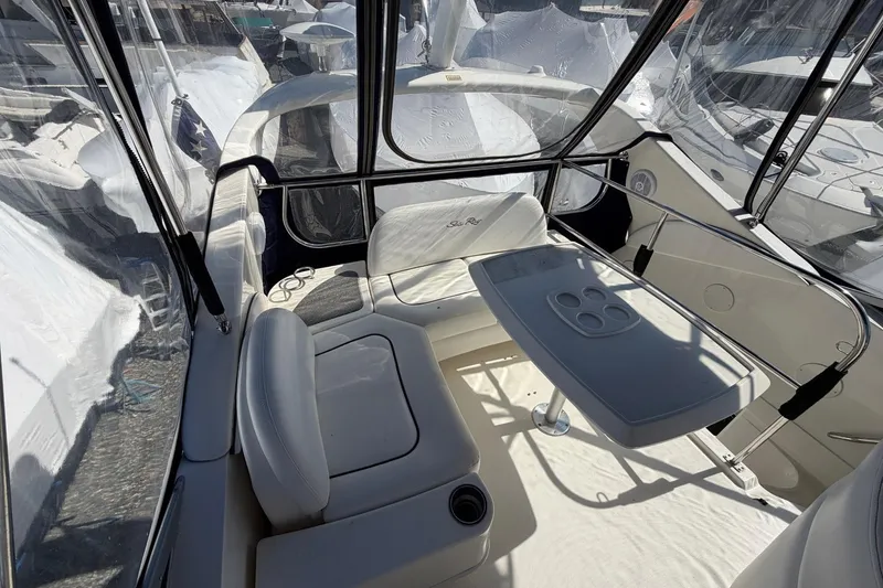 Slide: The Image of 2007 Sea Ray 36 Sedan Bridge interior with seating and table, enclosed by clear panels. - 13