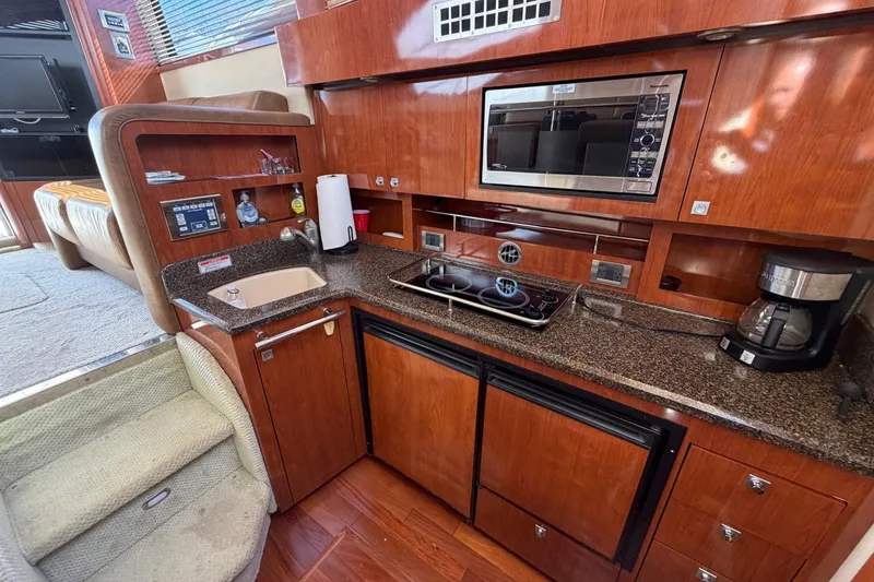 Slide: The Image of Luxurious 2007 Sea Ray 36 Sedan Bridge yacht kitchen with modern appliances and wood cabinetry. - 26