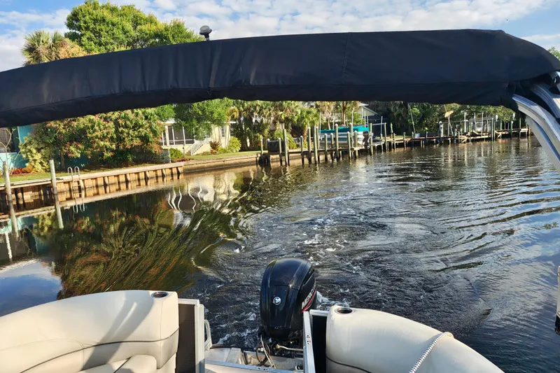 Slide: The Image of 2020 Cypress Cay Seabreeze 232 pontoon boat cruising on a scenic waterway. - 25