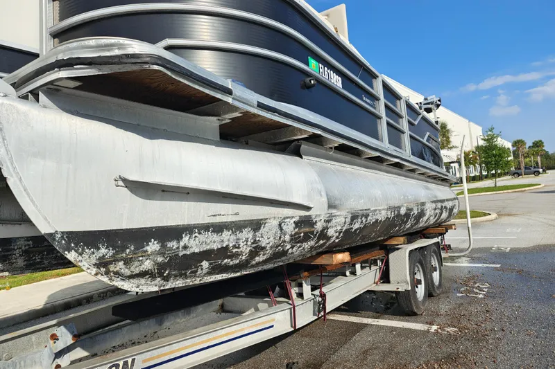 Slide: The Image of 2020 Cypress Cay Seabreeze 232 pontoon boat on trailer, showing wear and algae buildup. - 33