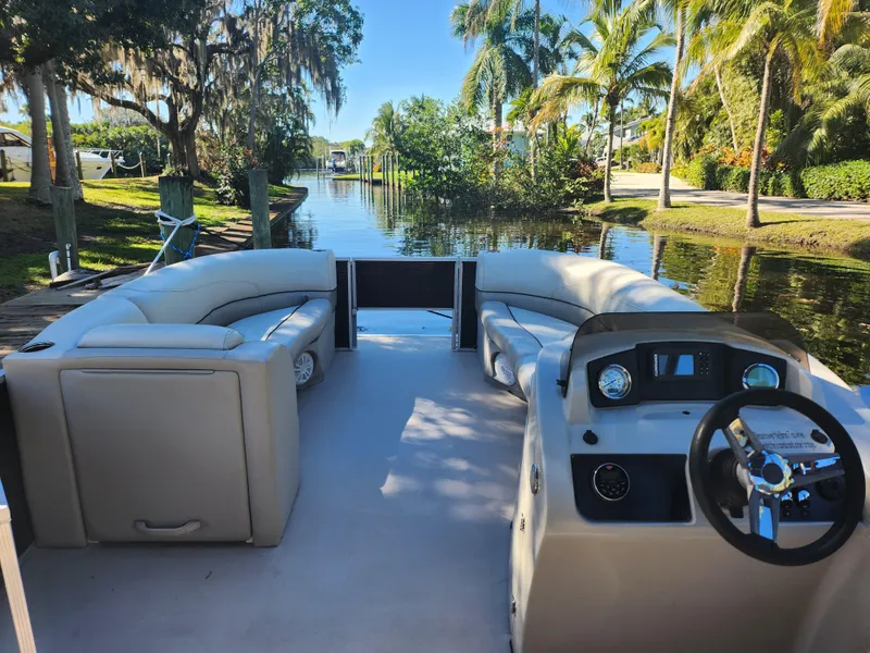 Slide: The Image of Interior view of a 2020 Cypress Cay Seabreeze 232 pontoon boat by the water. - 7