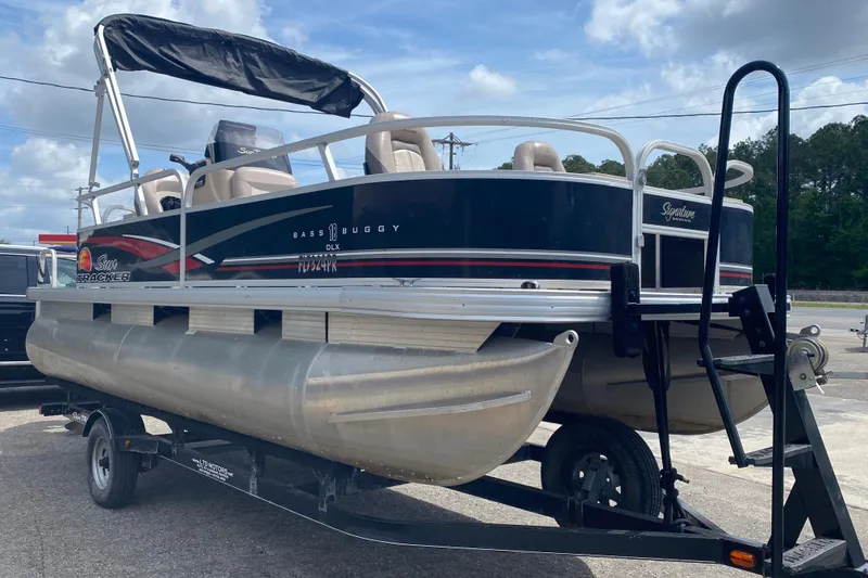 The Image of 2014 TRACKER MARINE SUN TRACKER 18 DLX pontoon boat on trailer, outdoor setting. - 1