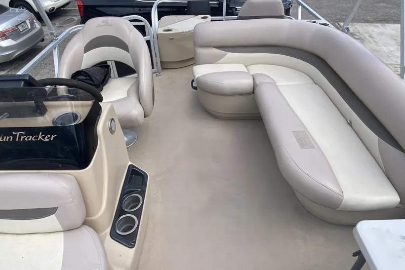 Slide: The Image of Interior of 2014 Sun Tracker 18 DLX pontoon boat with beige seating and steering console. - 4