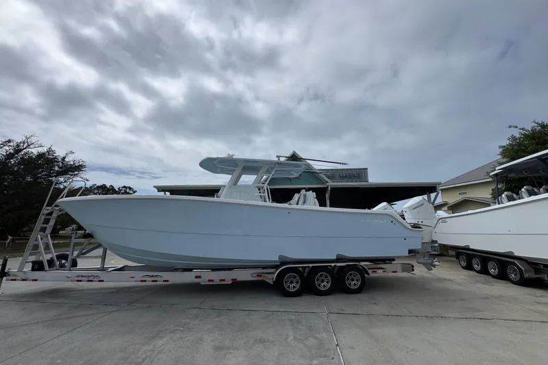 The Image of 2026 Invincible 33 Catamaran on trailer under cloudy sky. - 1