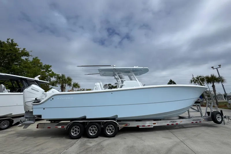 Slide: The Image of 2026 Invincible 33 Catamaran on trailer, sleek design under cloudy sky. - 10