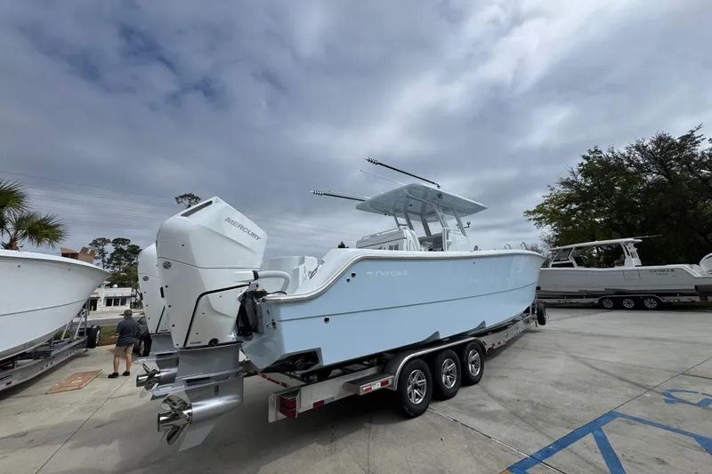 Slide: The Image of 2026 Invincible 33 Catamaran with Mercury engines on a trailer, parked outdoors. - 12