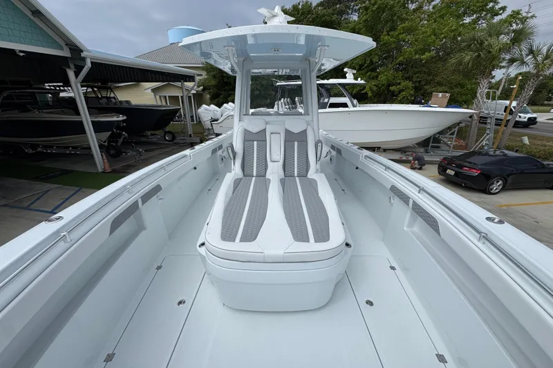 Slide: The Image of 2026 Invincible 33 Catamaran with sleek design and spacious seating at a marina. - 19