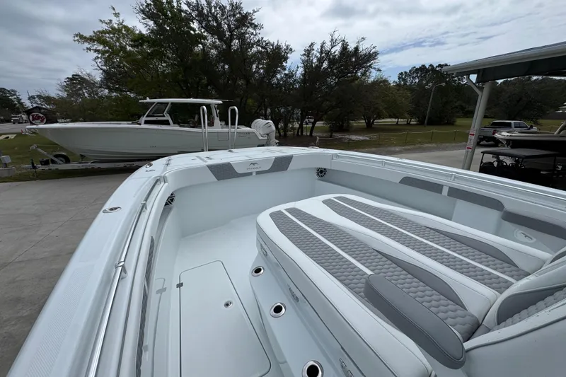 Slide: The Image of 2026 Invincible 33 Catamaran with sleek seating, parked outdoors on a cloudy day. - 22