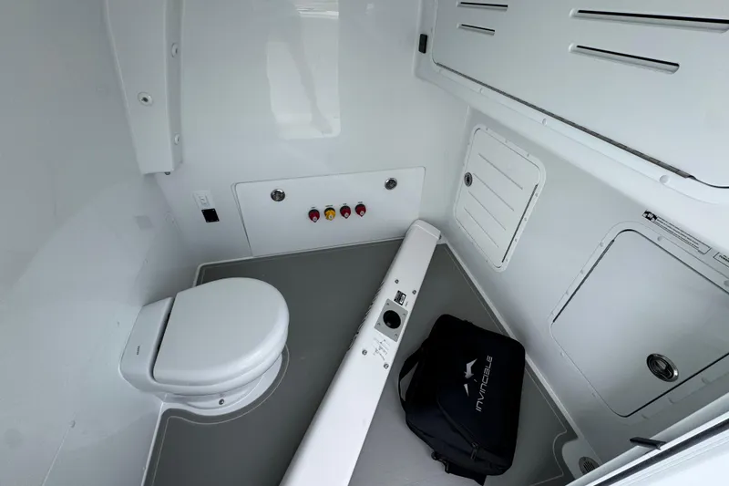 Slide: The Image of Interior of 2026 Invincible 33 Catamaran bathroom with toilet and storage compartments. - 25