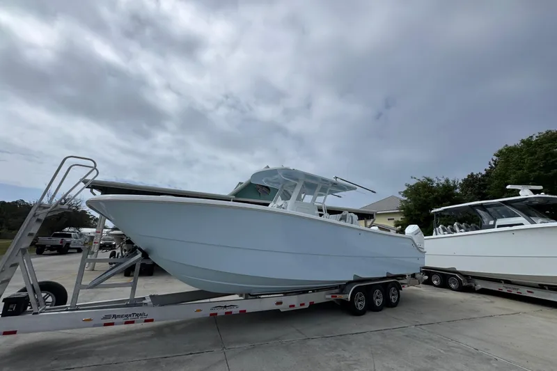 Slide: The Image of 2026 Invincible 33 Catamaran on trailer under cloudy sky. - 3