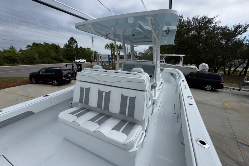 Slide: The Image of 2026 Invincible 33 Catamaran with sleek seating and modern design in a parking area. - 37