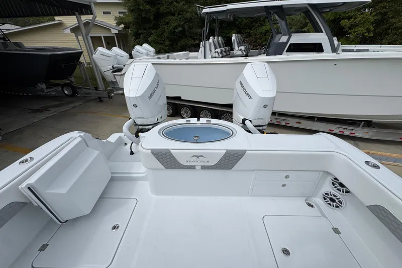 Slide: The Image of 2026 Invincible 33 Catamaran with dual Mercury engines in a boatyard setting. - 39