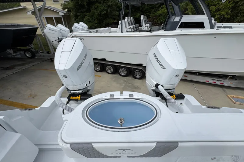 Slide: The Image of 2026 Invincible 33 Catamaran with dual Mercury outboard engines, docked on a trailer. - 40