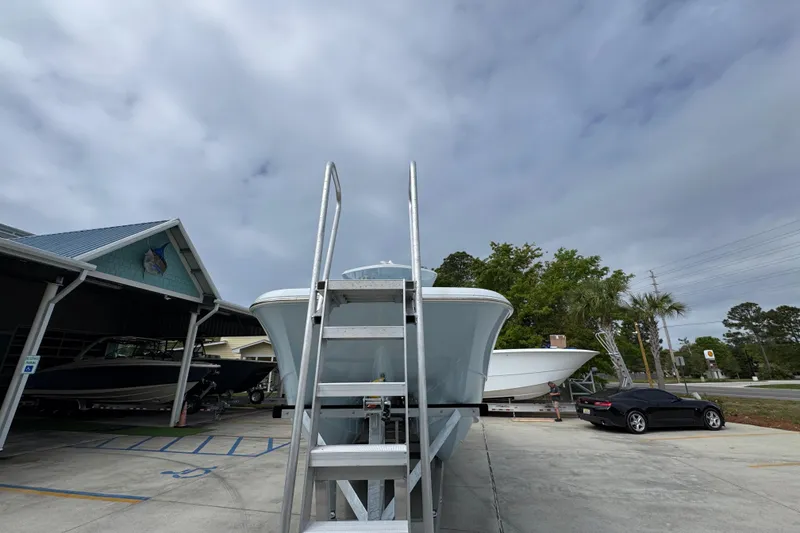 Slide: The Image of 2026 Invincible 33 Catamaran on trailer under cloudy sky at marina. - 6
