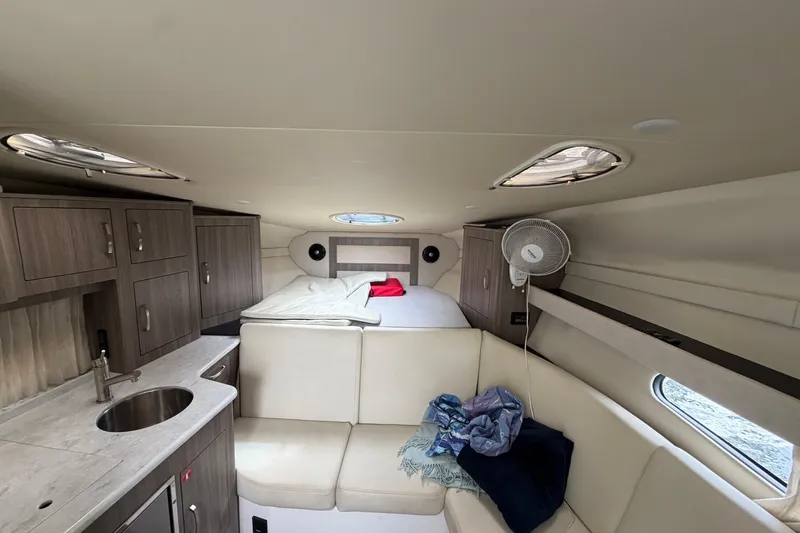 Slide: The Image of Interior of 2022 Regal 33 XO yacht with bed, kitchenette, and seating area. - 14