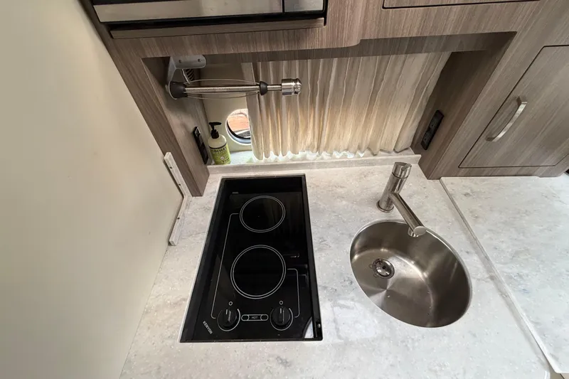 Slide: The Image of Compact kitchen area in 2022 Regal 33 XO boat with stove and sink. - 15