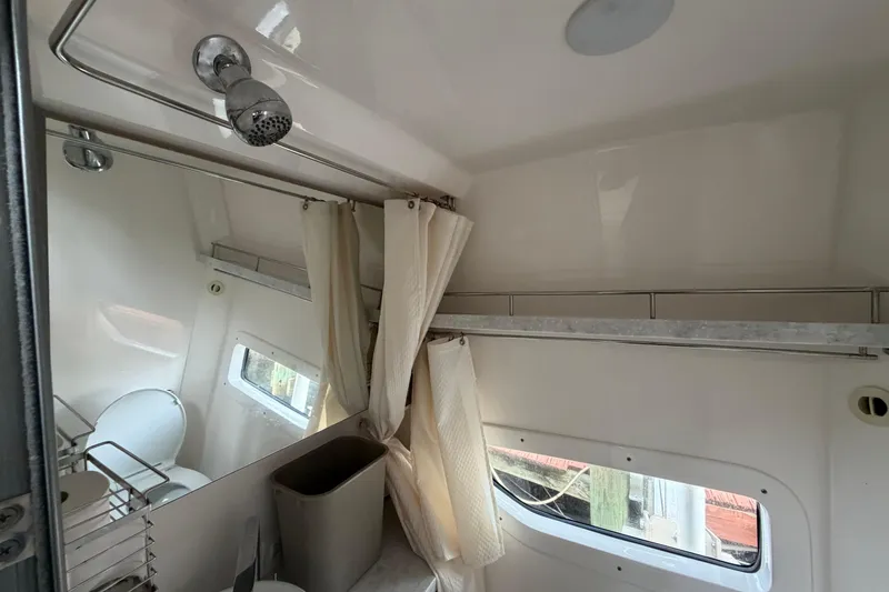 Slide: The Image of Interior of a 2022 Regal 33 XO boat bathroom with shower and window. - 18