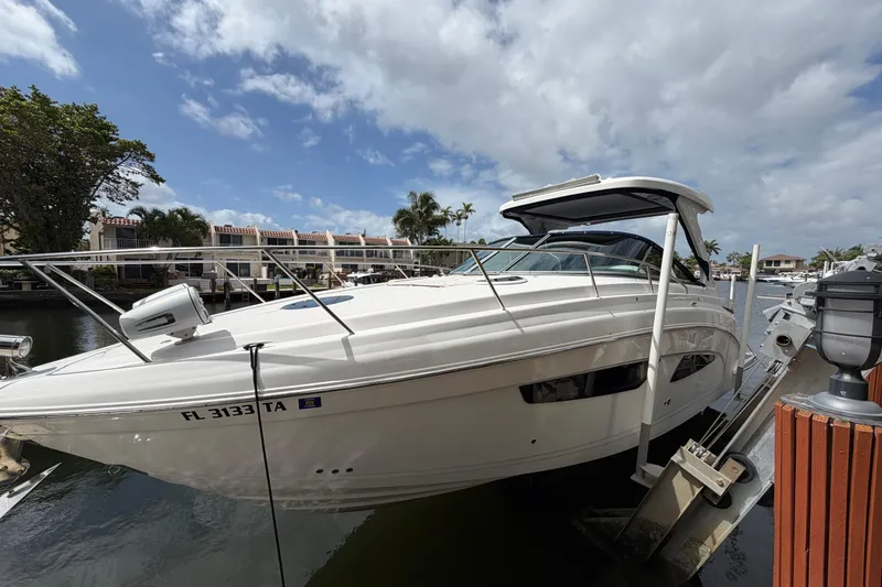 Slide: The Image of 2022 Regal 33 XO boat docked by waterfront homes under a cloudy sky. - 2