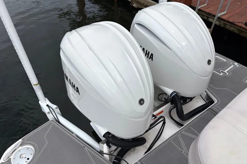 Slide: The Image of Twin Yamaha outboard engines on a 2022 Regal 33 XO boat, docked by the water. - 5