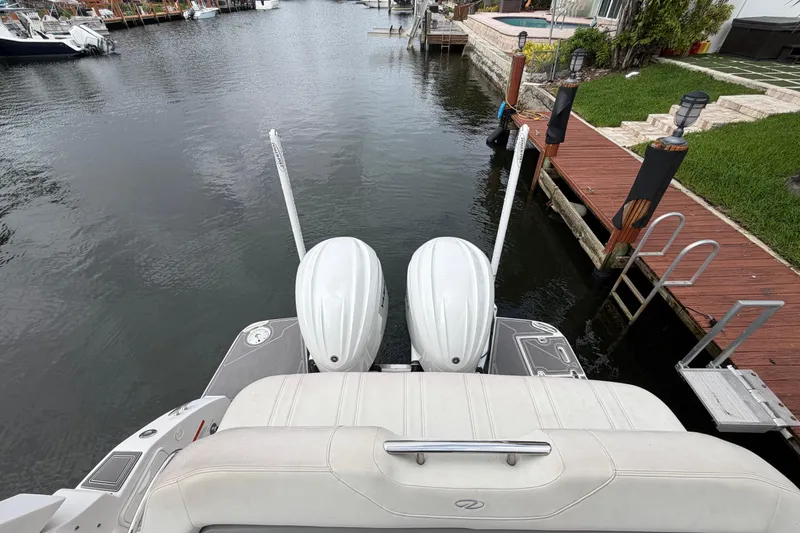 Slide: The Image of 2022 Regal 33 XO boat with dual engines docked by a wooden pier. - 6