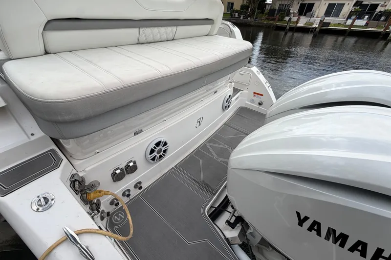 Slide: The Image of 2022 Regal 33 XO boat with Yamaha engines and cushioned seating by the water. - 7