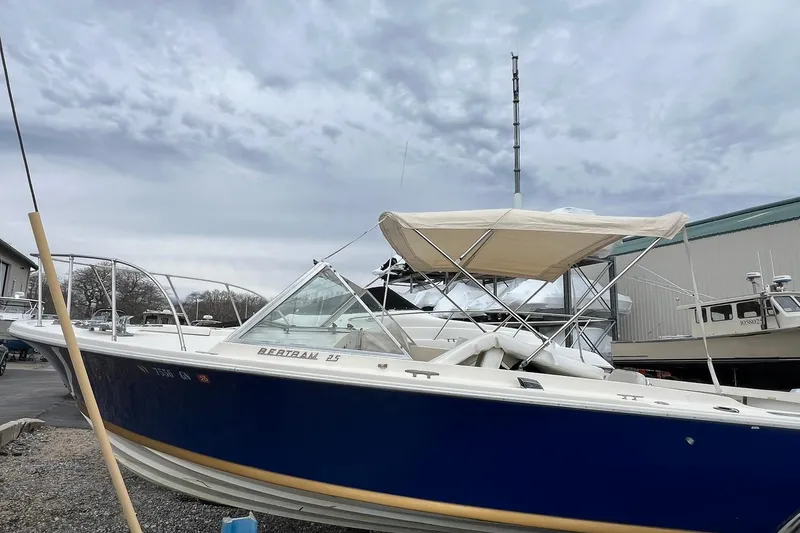 Slide: The Image of 1970 Bertram 25 Moppie boat with blue hull and canopy, docked outdoors. - 10
