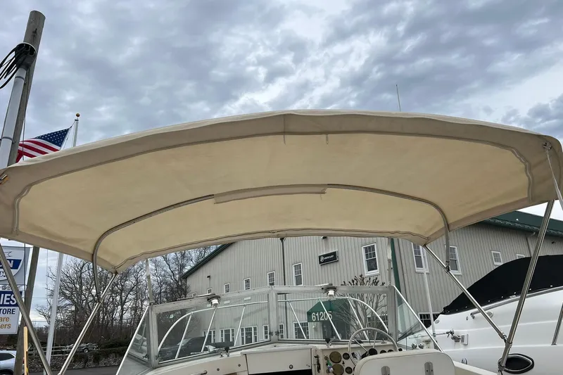 Slide: The Image of 1970 Bertram 25 Moppie boat with canopy, docked under cloudy sky. - 17