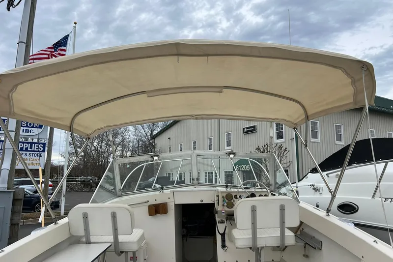 Slide: The Image of 1970 Bertram 25 Moppie boat interior with canopy, docked near American flag. - 19