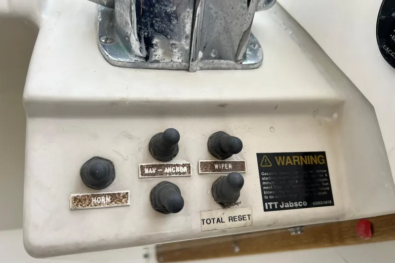 Slide: The Image of Control panel of a 1970 Bertram 25 Moppie boat with labeled switches and warning label. - 22