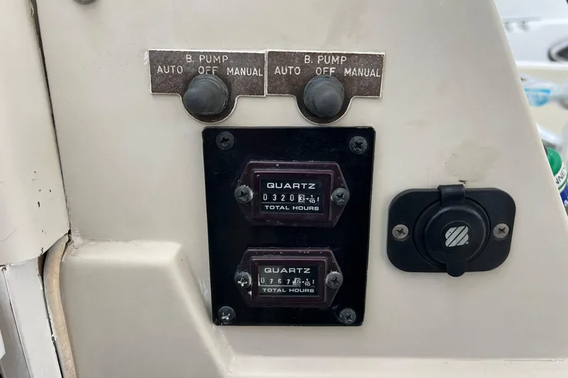 Slide: The Image of Control panel of a 1970 Bertram 25 Moppie boat with hour meters and switches. - 24